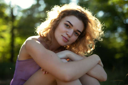 Beautiful curly woman summer portrait with soft smile