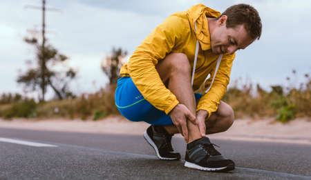 Runner man with shin trauma and pain on the road