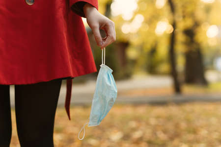 Surgical mask in a female hand, coronavirus is finishの写真素材