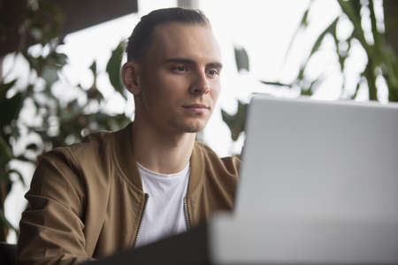 Freelancer man working by laptop PC sitting at table in a cafeの写真素材