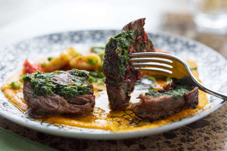 Prick veal medallion with a fork close-up, restaurant food