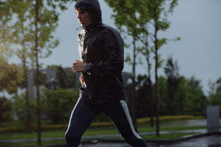 Man jogging under rain, flash lightの写真素材