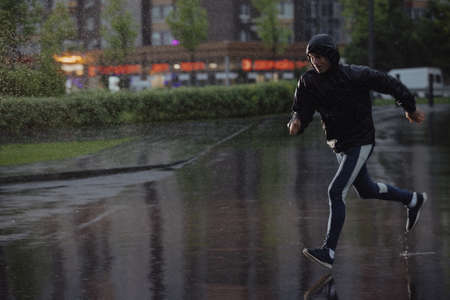 Man jogging under rain, flash lightの写真素材