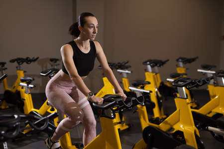 Fitness woman cycling exercise bike in gym