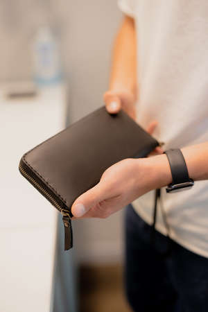 Man holding his leather wallet in a handsの写真素材