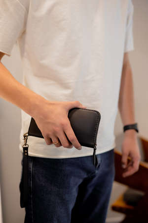 Man holding his leather wallet in a handsの写真素材