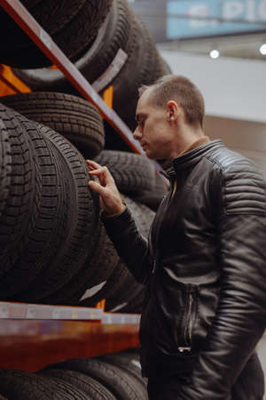 Man chooses winter car tires in the auto shopの写真素材