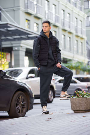 Fashionable man in grey costume and vest posing in a cityの写真素材