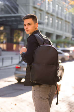 Tourist man with leather backpack in a cityの写真素材