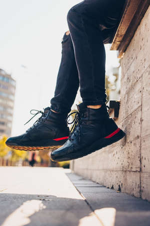 Fashion photo of male boots hanging against wall due to sitting upの写真素材