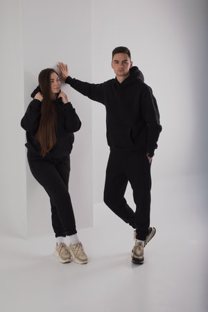 Couple posing in studio wearing black hoodie costumesの写真素材