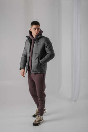 Man posing in studio wearing black winter jacketの写真素材