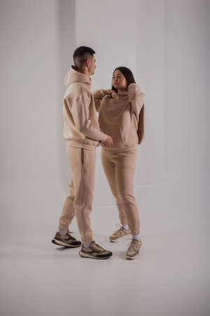 Couple posing in studio wearing beige hoodie costumesの写真素材