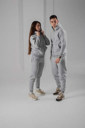 Couple posing in studio wearing gray hoodie costumesの写真素材