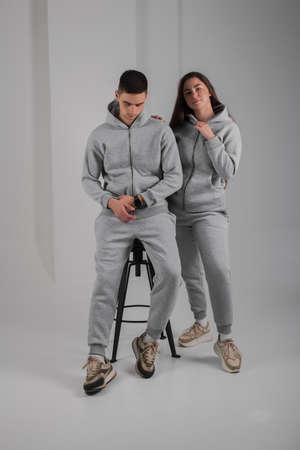 Couple posing in studio wearing gray hoodie costumesの写真素材