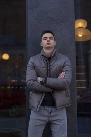 Man posing in city wearing grey winter jacketの写真素材