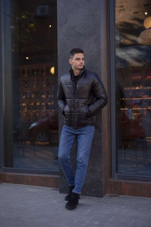Man posing in city wearing black winter jacketの写真素材