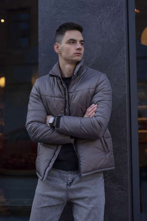 Man posing in city wearing grey winter jacketの写真素材