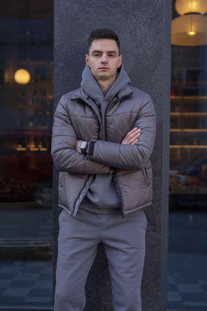 Man posing in city wearing grey winter jacketの写真素材