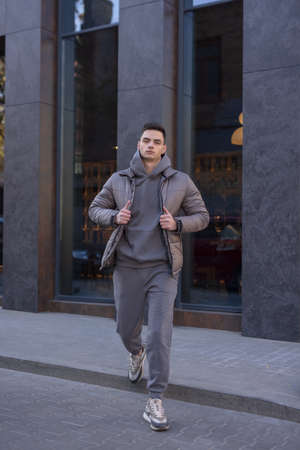 Man walking in city wearing black winter jacketの写真素材
