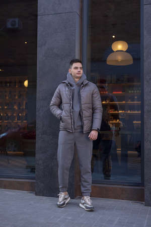 Man posing in city wearing grey winter jacketの写真素材