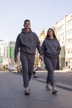 Couple walking in city wearing grey hoodie costumesの写真素材