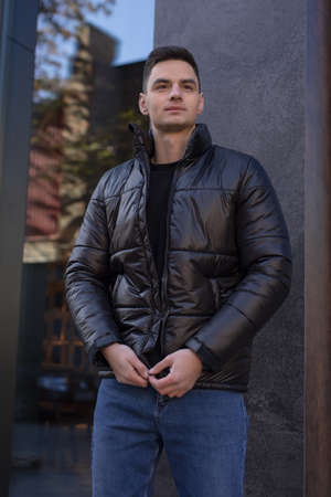 Man posing in city wearing black winter jacketの写真素材