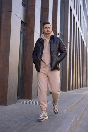 Man walking in city wearing black winter jacketの写真素材