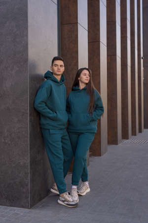 Couple posing in city wearing green hoodie costumesの写真素材