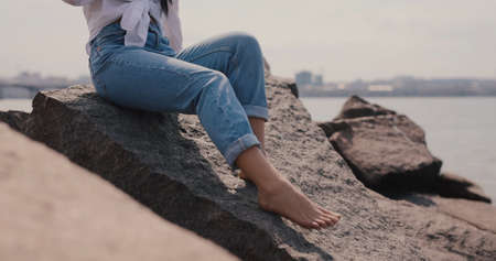 Female legs on the stones near the riverの写真素材