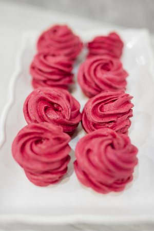 Many red and pink cooked marshmallows lie on the plateの写真素材