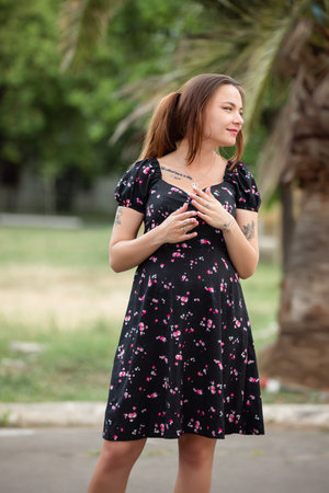 Pretty pregnant slim woman portrait in the dress at a natureの写真素材