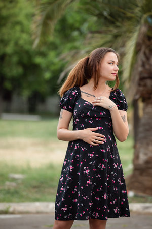 Pretty pregnant slim woman portrait in the dress at a natureの写真素材