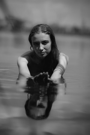 Black and white portrait of naked woman swimming in the lakeの写真素材