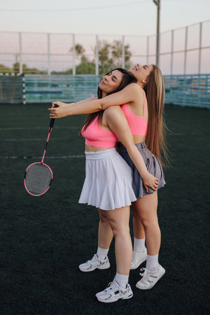 Girls badminton players in skirt posing on the tennis courtの写真素材