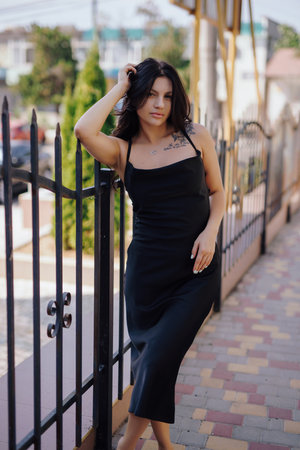 Attractive lady posing in the black dress in a cityの写真素材