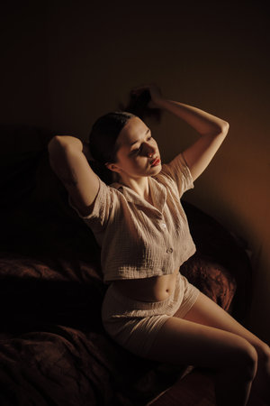 Beautiful woman home creative portrait in low key at the morningの写真素材