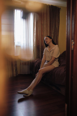 Woman home portrait in a bedroom at the morningの写真素材