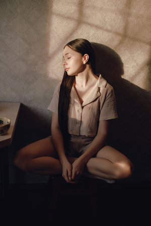 Relaxing woman sitting on kitchen in sunlight