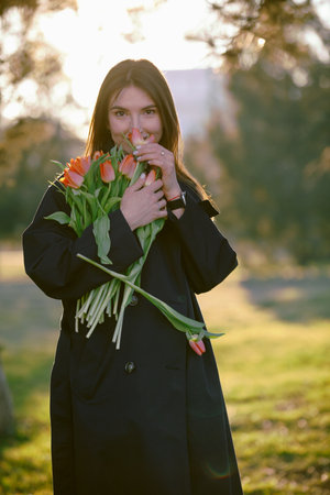 Happy woman sniff a bouquet of tulip flowers at the spring dayの写真素材