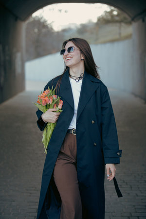 Happy woman holding tulip flowers in the tunnel at the spring dayの写真素材
