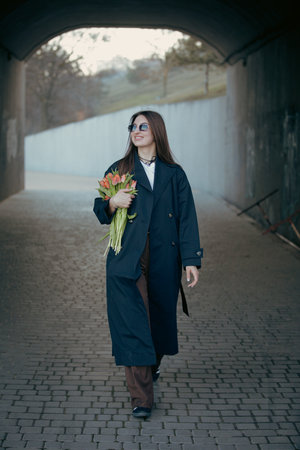 Happy woman holding tulip flowers in the tunnel at the spring dayの写真素材