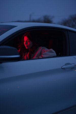 Portrait of woman in the car with red lightの写真素材