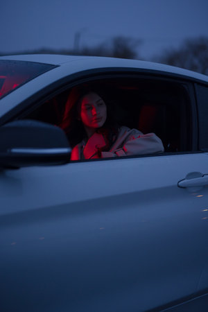 Portrait of woman in the car with red lightの写真素材