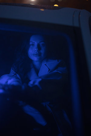 Lady posing in the car in blue light at nightの写真素材