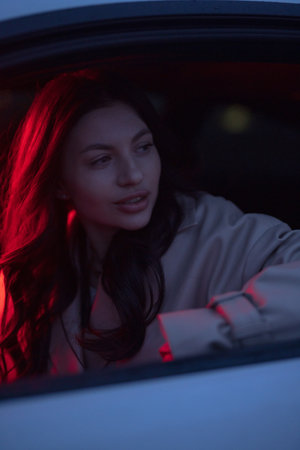 Portrait of woman in the car with red lightの写真素材