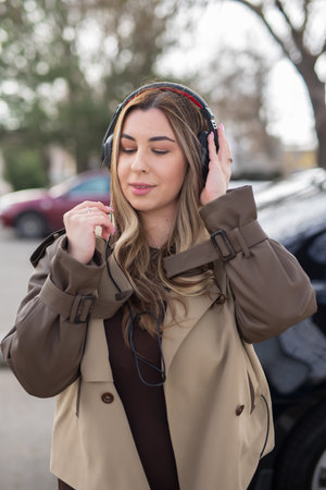 Beautiful woman wearing headphones at the city street listen musicの写真素材