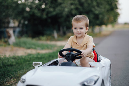 2 years boy riding electric car toy on the roadの写真素材