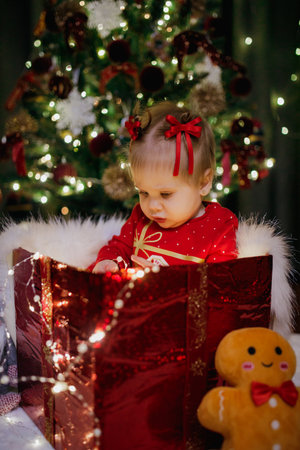 Little girl sitting in a gift box at the Christmas dayの写真素材