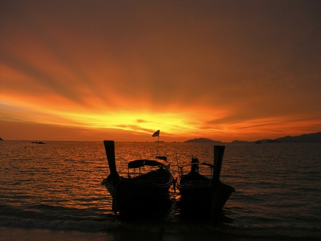 silhouette sailing boats after sunset with  sun rays  sky shapeの写真素材